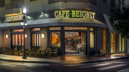 The exterior of Cafe Beignet Sheraton at night.