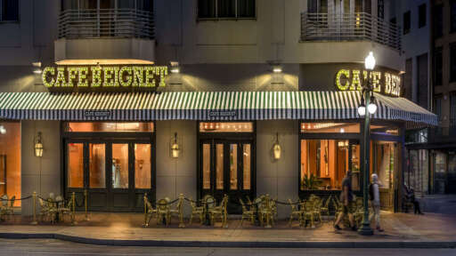 The exterior of Cafe Beignet Sheraton at night.